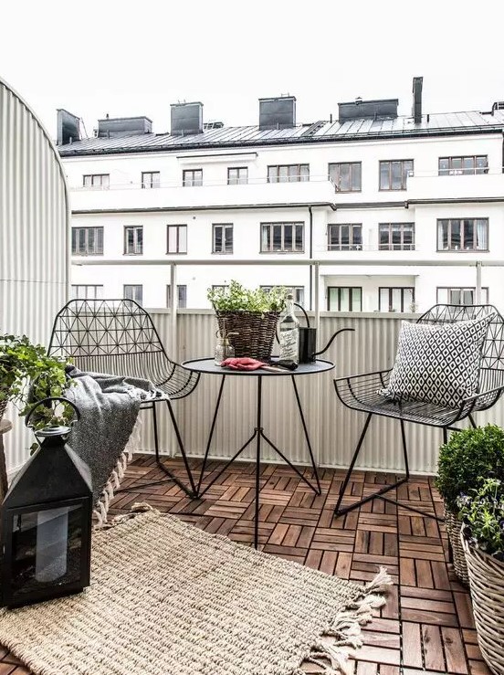 balcon avec plancher en bois et des chaises en métal
