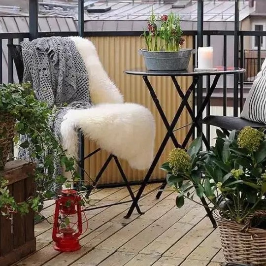 balcon avec chaise en métal et tapis en fourrure