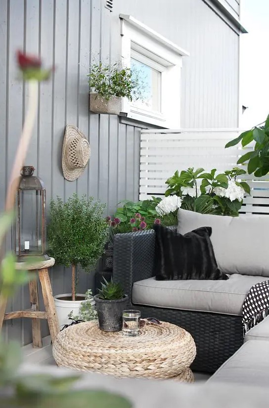 balcon avec table et canapé en osier