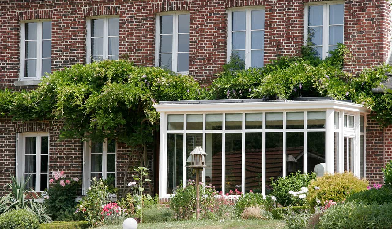 véranda blanche sur maison en briques