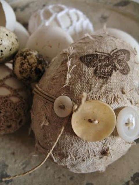 œufs de Pâques avec des boutons et de la ficelle